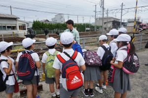 構内見学で説明を聞く児童